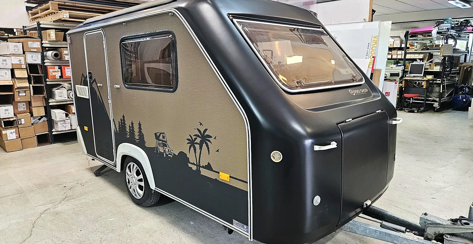 Campingvogna etter helfoliering, med sort front og olivengrønne sider med motiv
