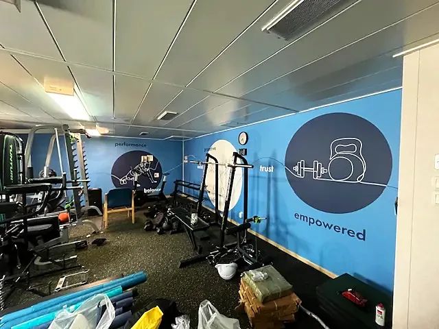 Treningsrom med ikoner og ordet empowered på veggen