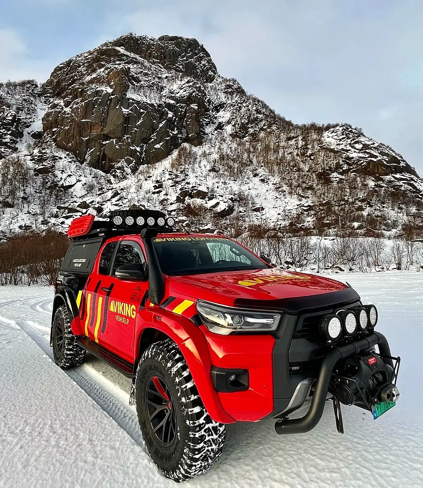 Arctic Trucks Hilux med Viking Veihjelp-dekor i snøen