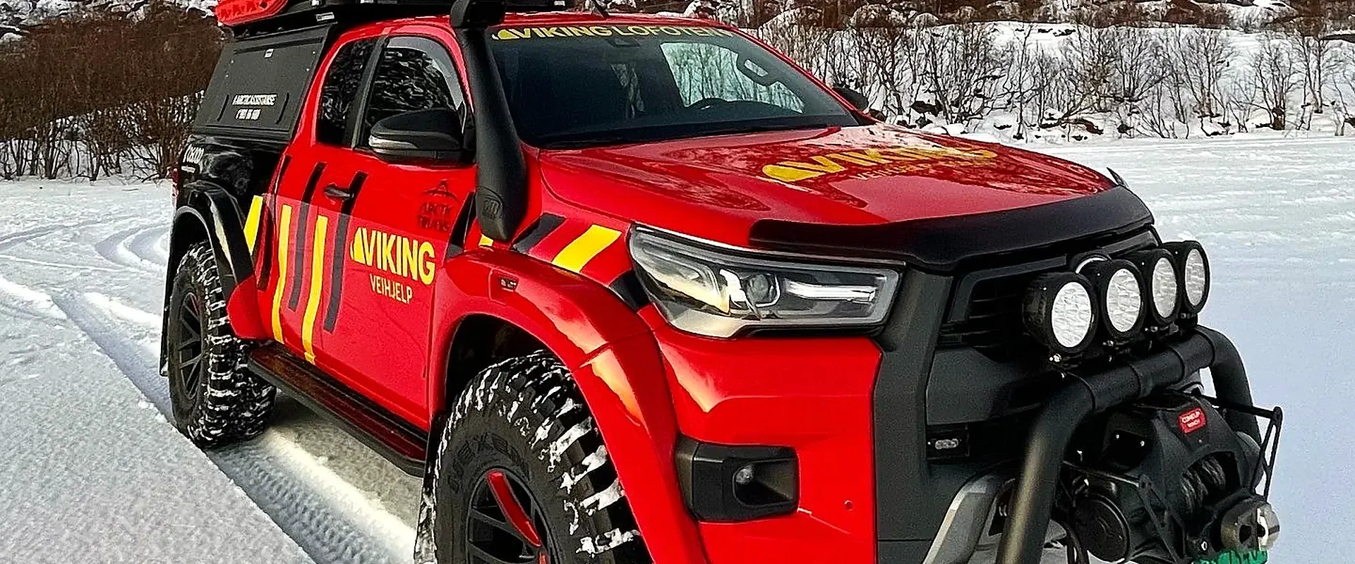 Arctic Trucks Hilux med Viking Veihjelp-dekor i snøen