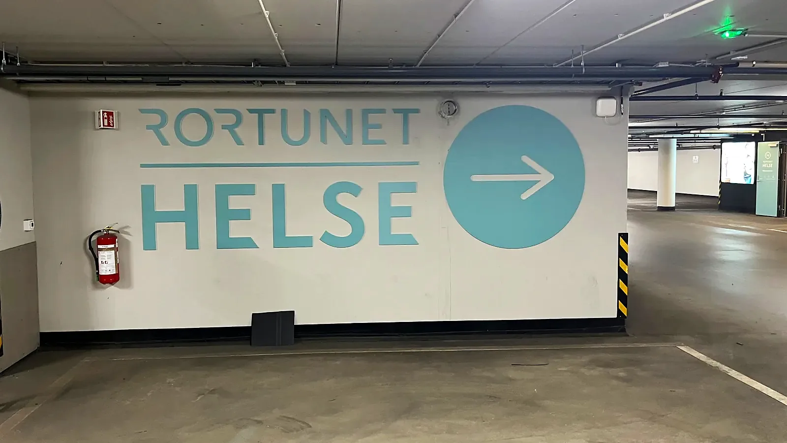 Rortunet Helse med logo og pil i utfrest PVC på veggen i P-huset