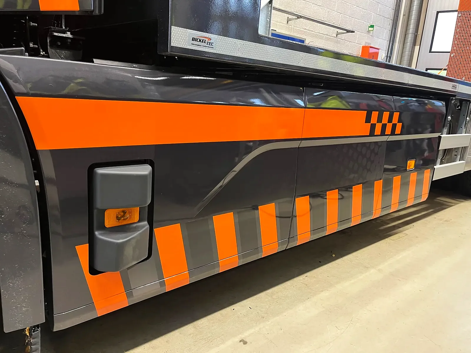Sideskjørt på Volvo med oransje og grå refleksstriper