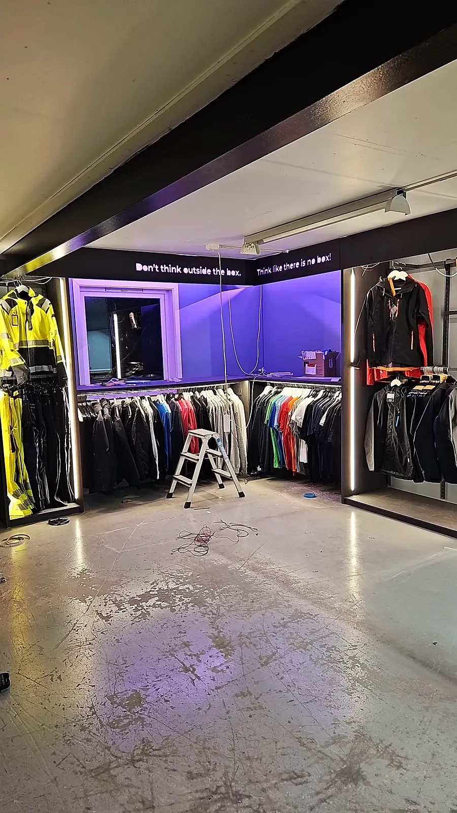 Showroom med arbeidsklær og lilla lys, før de siste detaljene