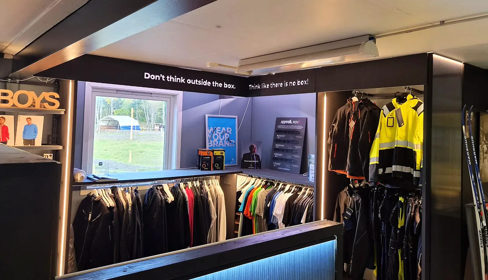 Nesten ferdig showroom med arbeidsklær, lys og mottoet «Don't think outside the box»