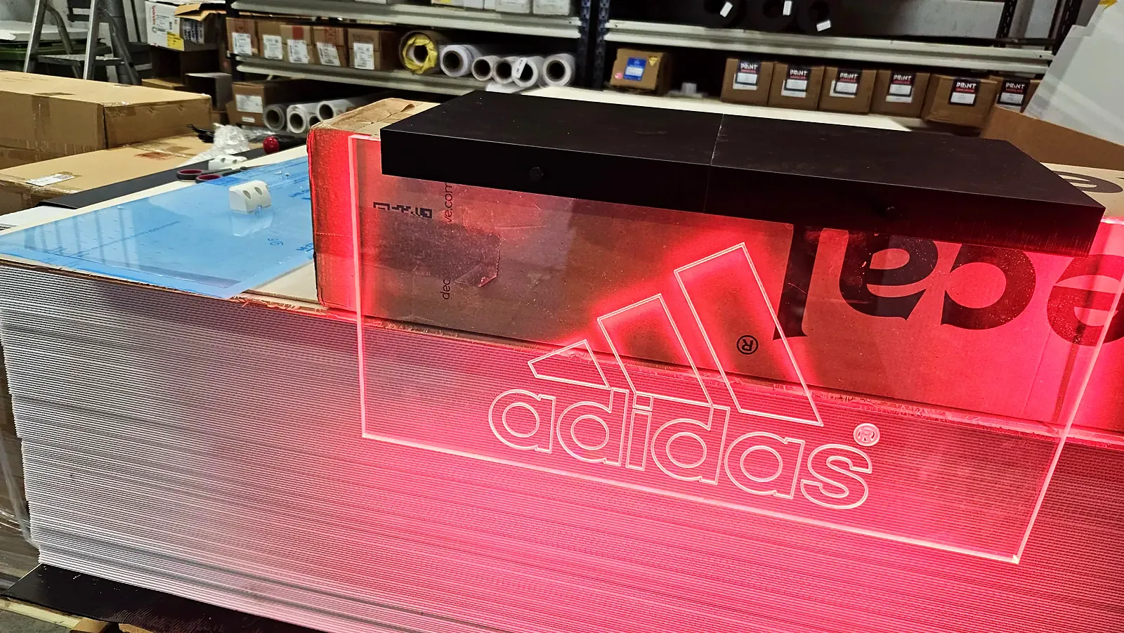 Adidas-logo i akryl med rødt LED-lys