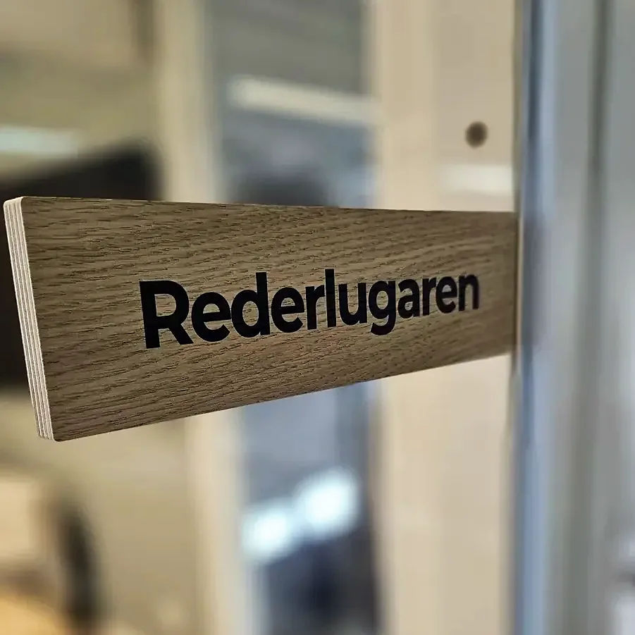 Utstikkende dørskilt i tre med teksten Rederlugaren